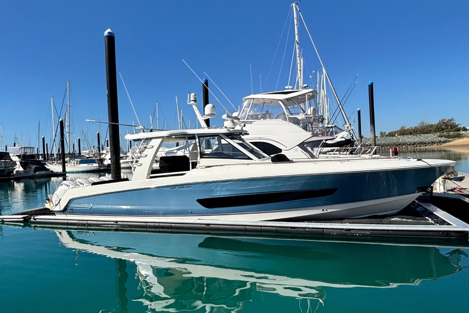 Boat docked in a SeaPen in a marina.