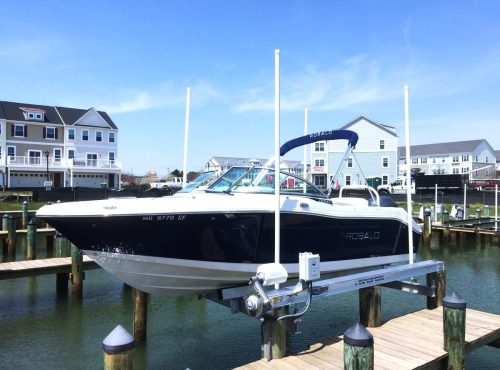 Four-post boat lift holding a boat above the water